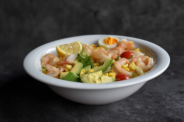Fresh salad with prawns, egg and lemon. Full of vitamins with fruits and vegetables. Cucumber, quinoa, tomato, orange, corn, onion and avocado