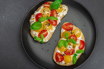 Fresh bread sandwiches with tomato cherry, cream cheese and basil leaves. Morning breakfast concept