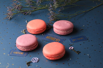 Tasty lilac macarons and lavender flowers on a pastel dark blue and gold stars  background with minor keys of happiness and tickets