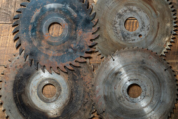 Old circular saw blades on wooden table, closeup, top view. Carpentry tools, sawing equipment
