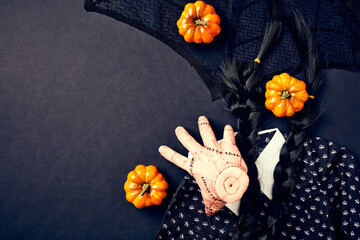 Flat lay composition with Halloween party elements. Top view served hand the Thing, pumpkins,...