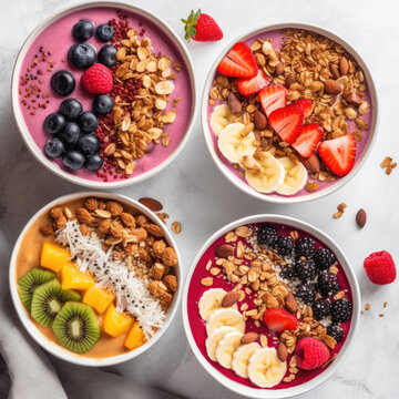 Top view of four fruit-filled smoothie bowls