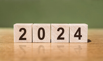The year 2024 text on wooden cube. A new era of creative inspiration and concept background. Make a...