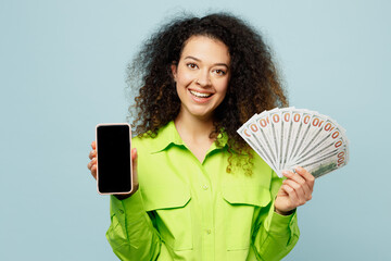 Young happy latin woman wear green shirt casual clothes hold blank screen mobile cell phone, fan of...