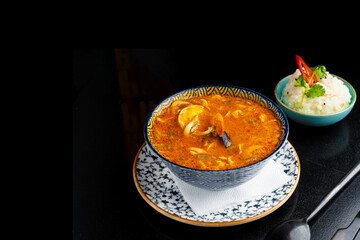 traditional azian tom yam soup on plate on black background