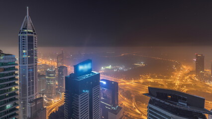 Aerial skyline with Golf Club, hotels and residential areas far away in desert in Dubai all night,...