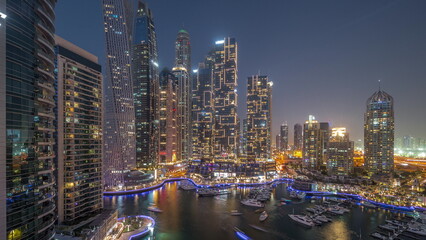 Dubai marina tallest skyscrapers and yachts in harbor aerial day to night.
