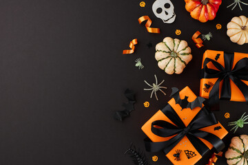 Infusing Halloween with happiness through thoughtful gifts. Top view of gift boxes with black...