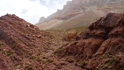 Les gorges tizi N'Ghougoult Atlas maroc, avec des rochers et sa terre rouge, sa peu de végétation, ruisseau d'eau, parcours sportif, beauté naturelle, exploration à l'inconnu, vaste zone montagnarde