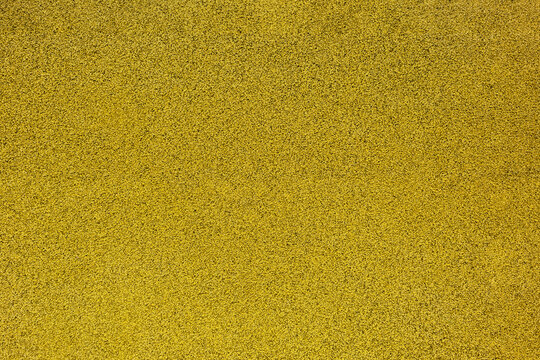 Grainy yellow texture made of rubber tiles