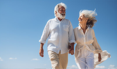 Happy senior couple walking and holding hand under blue sky. Retirement travel concept