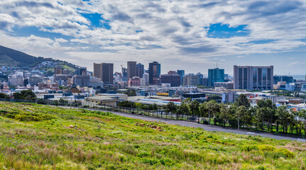 Cape Town city buildings on a cloudy afternoon wih a grass field in the foreground, Cape Town,...
