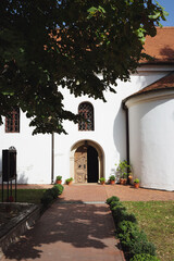 Green park alley and the entrance to the old orthodox church Sremski Karlovci Serbia