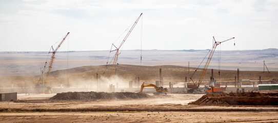 Lifting cranes and other equipment at a construction site. A group of lifting platforms for...