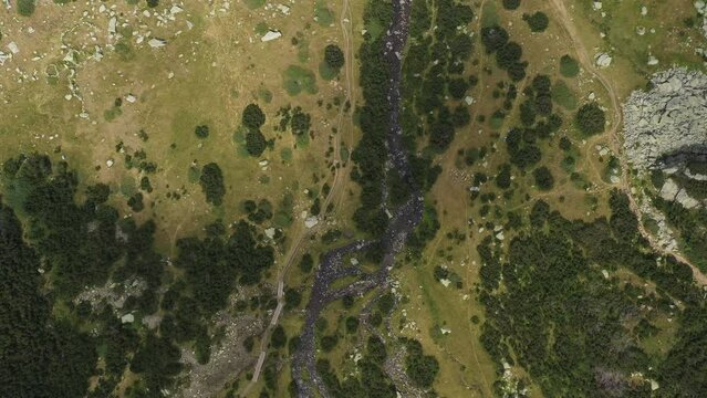 Aerial descent from top over tourist hiking paths in Pirin mountain in Bulgaria, Europe. HQ 4K Apple ProRes aerial video.