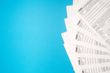 Top view of Forms 1040 U.S. Individual income tax return on a blue background