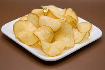 cassava chips isolated on brown background