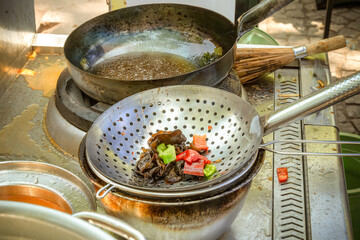 Cooking Asian food from meat and vegetables in a wok on the street. Fast food