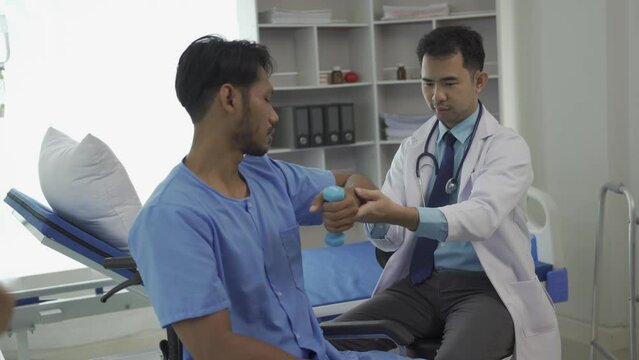 A Man do exercises with elastic band, Physiotherapy Program, Healthcare Concept Doctor helping patient in wheelchair with dumbbells doing rehabilitation exercise in medical center