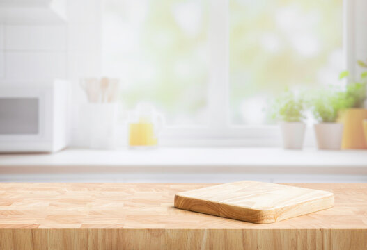 Selective focus.End grain wood counter top with cutting board on blur kitchen in morning window background