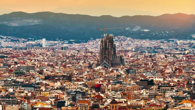 Aerial Shot of Bas&iacute;lica i Temple Expiatori de la Sagrada Fam&iacute;lia At Sunset. Avinguda de Gaud&iacute;, beautiful panorama. European cityscape. Mediterranean city. Aerial establishing shot of Barcelona. 