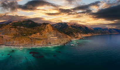 Sunset over Pitkins Curve Bridge and Rain Rocks Rock Shed along Pacific Coast Highway and Big Sur coastline in California, USA.