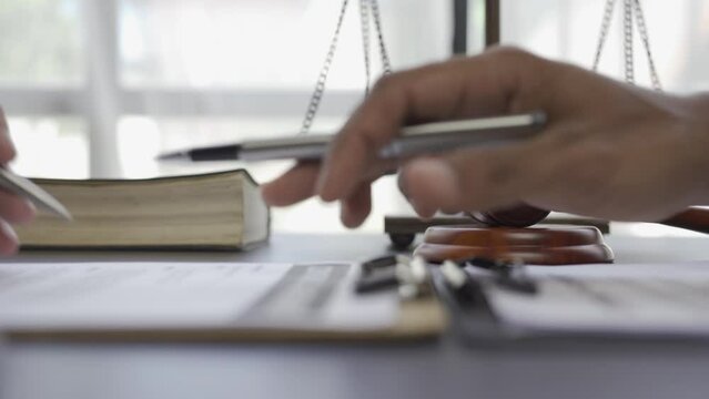 Lawyer reading statute of limitations, consultation between male lawyer and business client Tax and legal company with brass scales on table in office, law