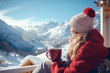 Fototapeten Young woman enjoying a hot drink among a snowy winter landscape, enjoying the holiday season. © Iryna