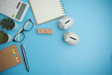 Top view VAT on wood cubes blocks on a blue background with copy space calculate annual taxes concept. Accounting, Vat, income tax. Calculation of taxes annual years.