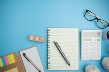 Top view VAT on wood cubes blocks on a blue background with copy space calculate annual taxes concept. Accounting, Vat, income tax. Calculation of taxes annual years.
