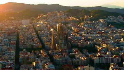 Aerial Shot of Basílica i Temple Expiatori de la Sagrada Família At Sunset. Avinguda de Gaudí, beautiful panorama. European cityscape. Mediterranean city. Aerial establishing shot of Barcelona. 