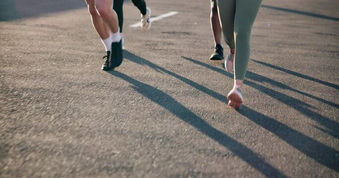 People, legs and running on road in fitness, outdoor exercise or cardio training on asphalt. Closeup of active or athlete group of runners feet in sprint, race or practice on street for lose weight