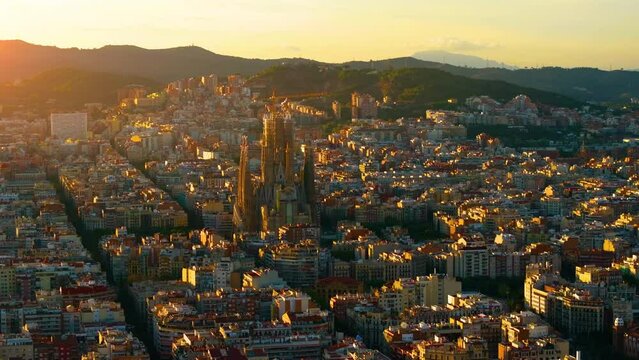 Aerial Shot of Bas&iacute;lica i Temple Expiatori de la Sagrada Fam&iacute;lia At Sunset. Avinguda de Gaud&iacute;, beautiful panorama. European cityscape. Mediterranean city. Aerial establishing shot of Barcelona. 