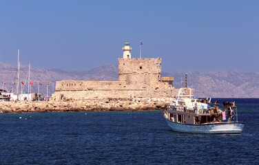 Old stone lighthouse on the breakwater in Rhodes.