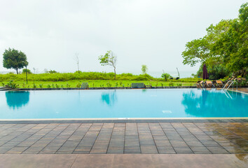 Beautiful blue clean swimming pool of a tourist hotel. Background for tourism, advertising and design. August 15, 2023, Sooriya Resort Spa, Sri Lanka - obrazy, fototapety, plakaty