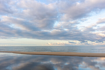 Dawn on the sea beach with cloudy sky