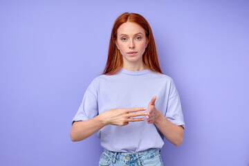 British sign language. A two-handed alphabet. Fingerspelling alphabet. red-haired woman showing deaf mute BSL alphabet, number 300 closeup portrait isolated blue background