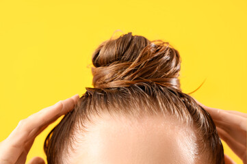 Naklejka premium Young woman after washing hair on yellow background, closeup