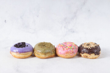 Delicious sweet donuts with different flavors on a table. Isolated image on white background