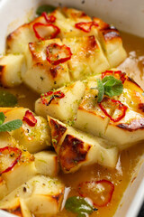 Baked halloumi with honey and chilli served with fresh mint leaves, green salad and grilled pitta bread