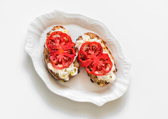 Obraz na płótnie Canvas Stracciatella cheese, bruschetta tomatoes on a light background, top view