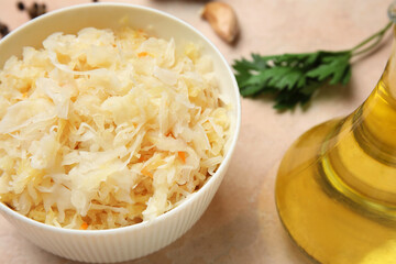 Bowl with delicious sauerkraut on pink background