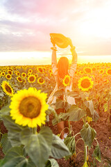 Woman sunflower field. Happy girl in blue dress and straw hat posing in a vast field of sunflowers...