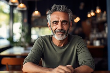 portrait of Hispanic older man smiling in cafe
