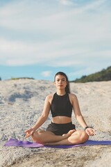 Fototapeta na wymiar Beautiful woman doing yoga on the beach.
