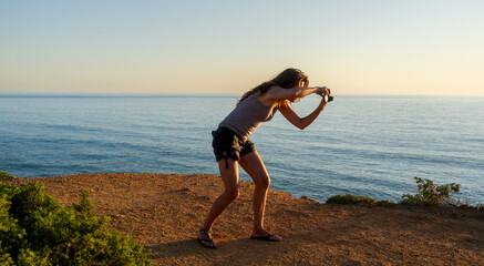 Woman capturing the horizon over the ocean at the beach. With copyspace