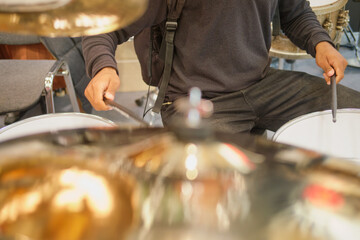 Drummer playing drum set in music studio. Close up of man playing drums