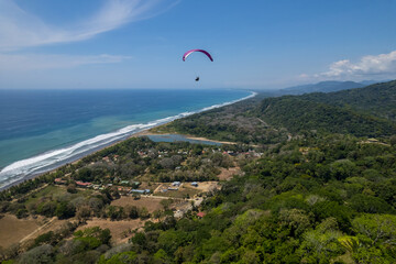 Aerial View of extreme paragliding sport in the Beautiful beach in Dominical - Costa Rica 