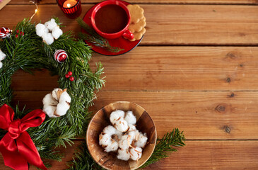 winter holidays, diy and hobby concept - close up of christmas fir wreath making stuff, decorations and hot chocolate on wooden table