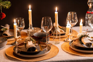 winter holidays, dinner party and celebration concept - scandinavian christmas table serving with burning candles at home over black background - Powered by Adobe